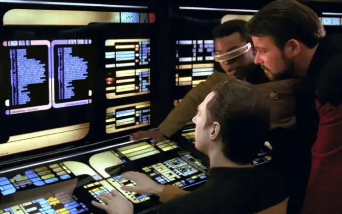 Data, Geordi, and Riker look at a computer interface on the U.S.S. Enterprise-D