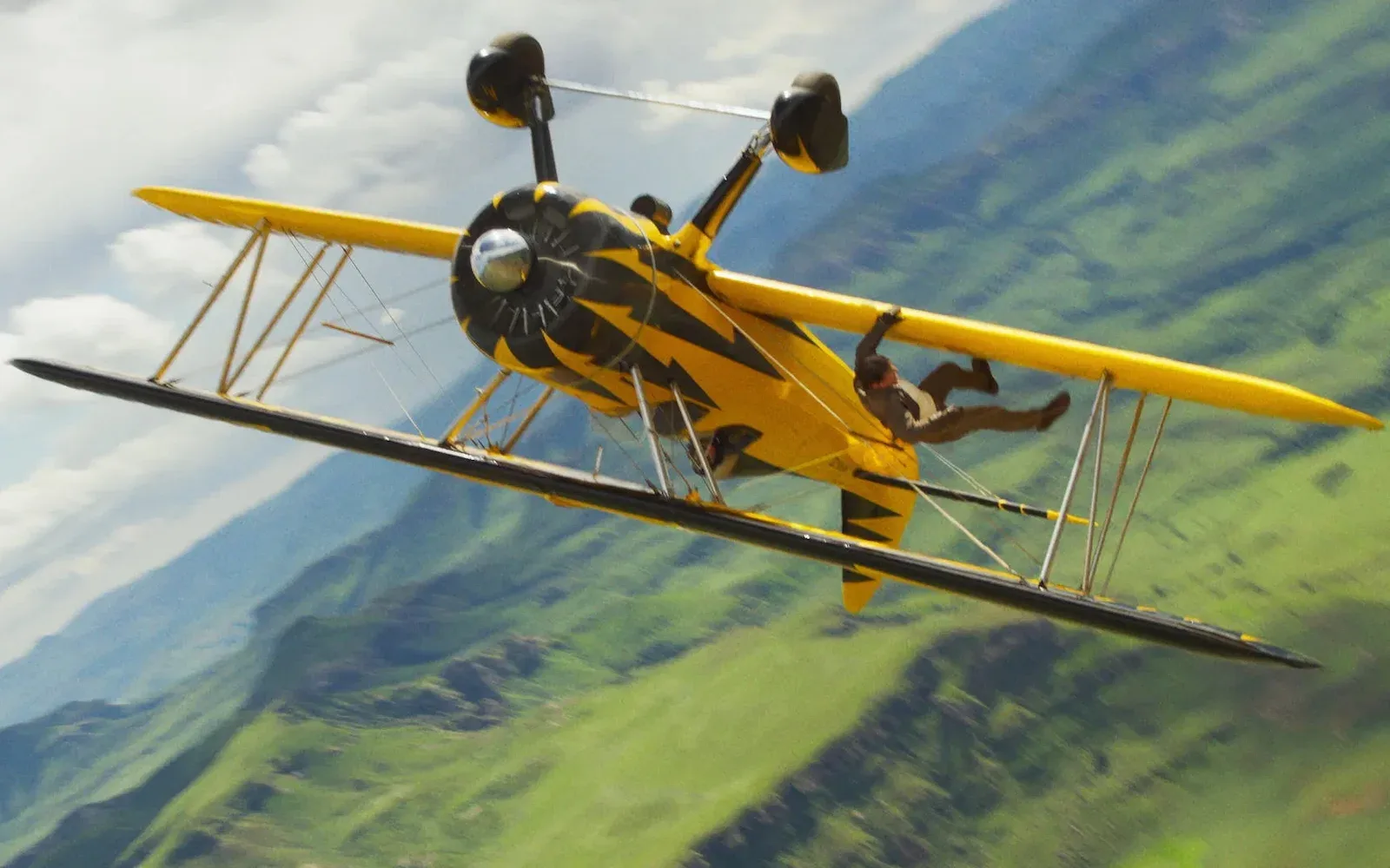 Tom Cruise dangles from a yellow biplane in this stunt from Mission: Impossible -- The Final Reckoning