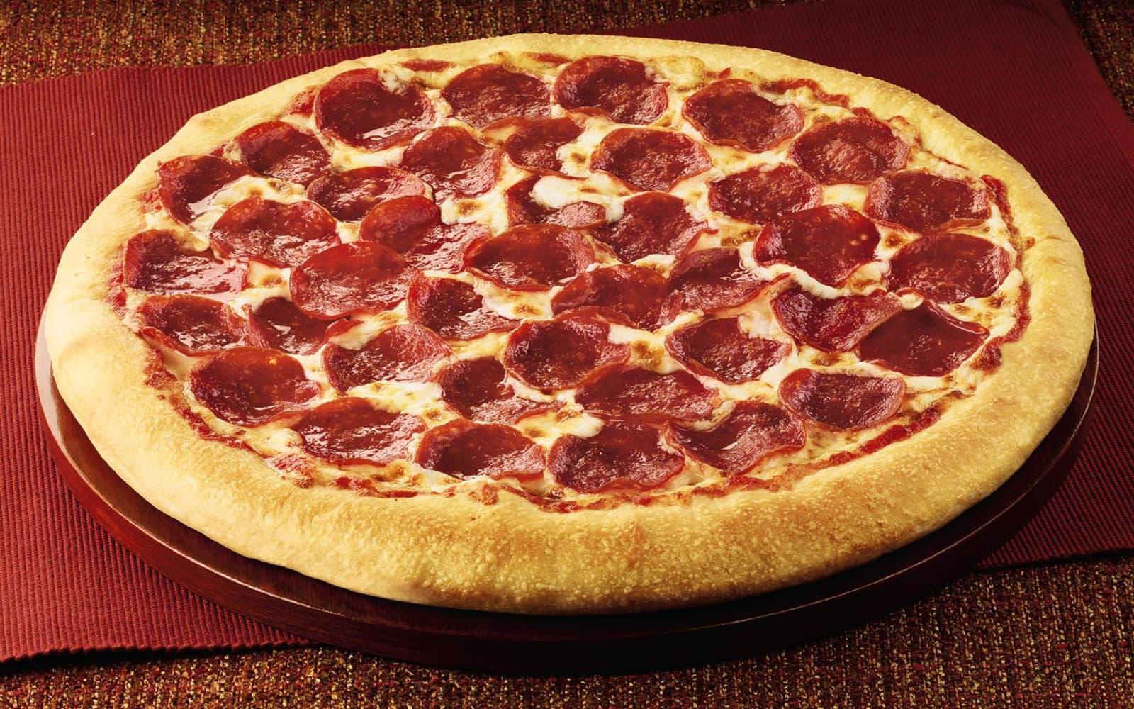 A pizza covered in pepperoni
