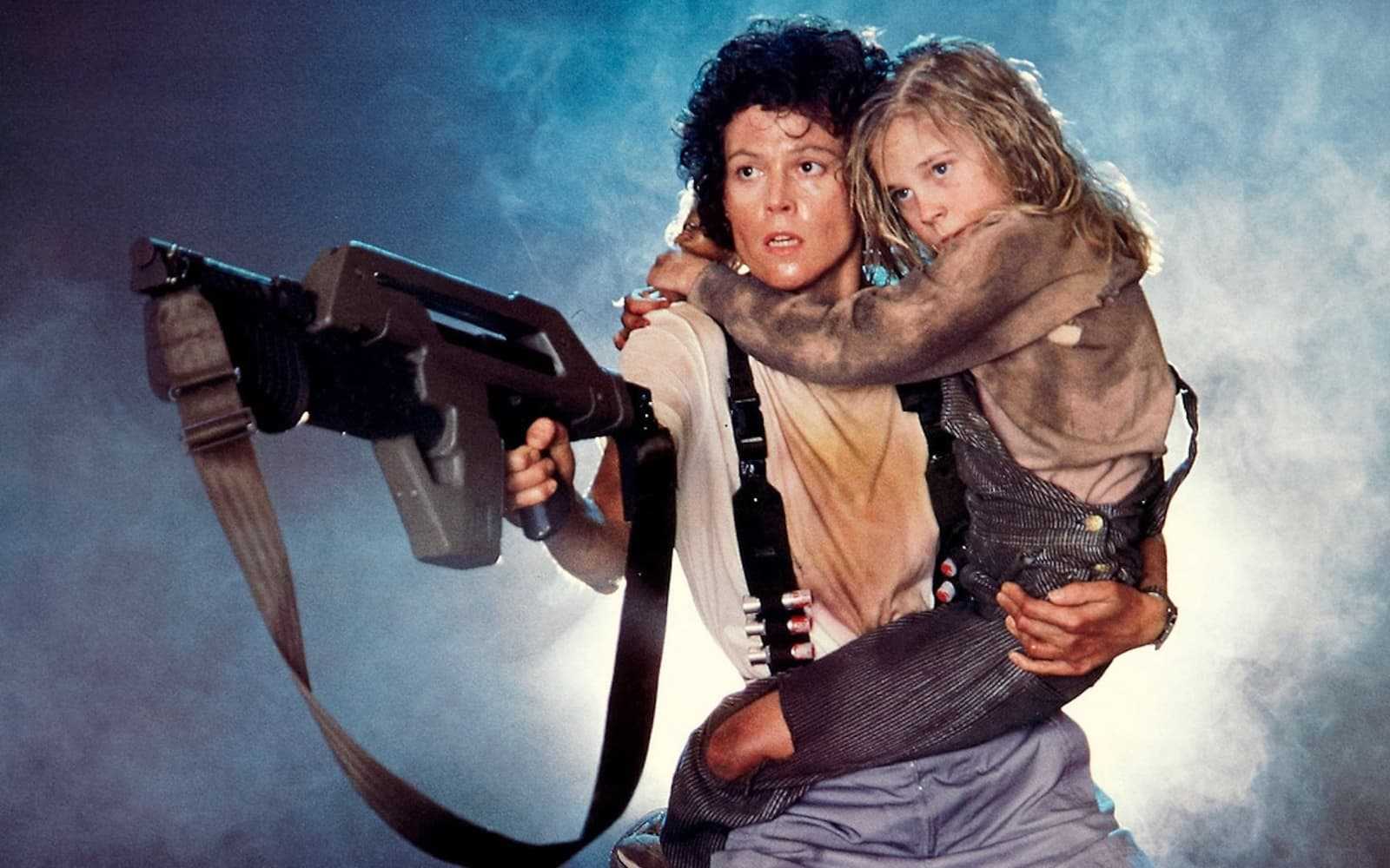 Sigourney Weaver is carrying a big gun and a young girl in this still from Aliens