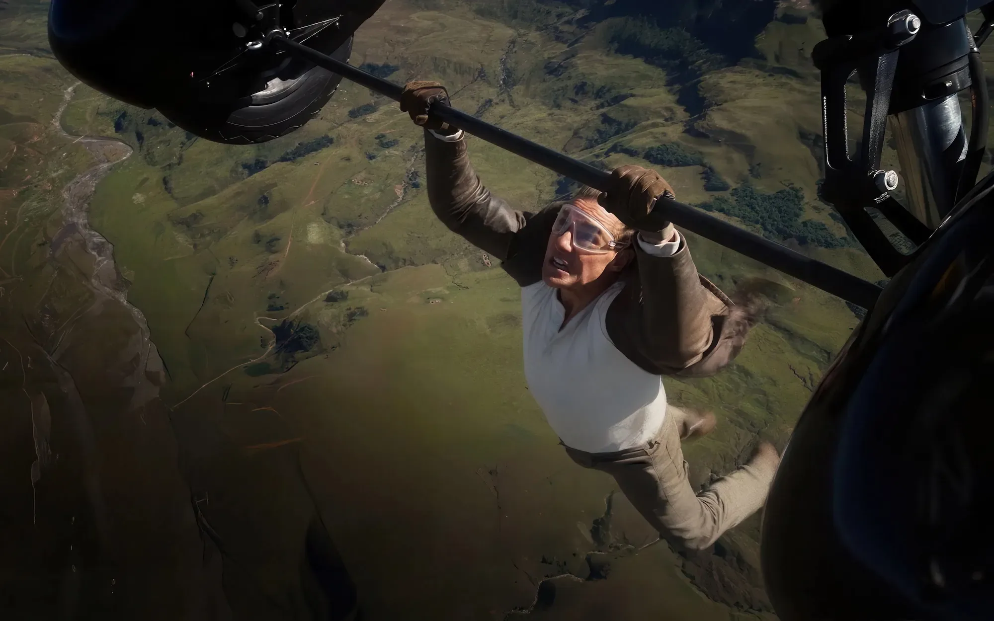 Tom Cruise hangs from the bottom of an airplane in this still from Mission: Impossible - The Final Reckoning