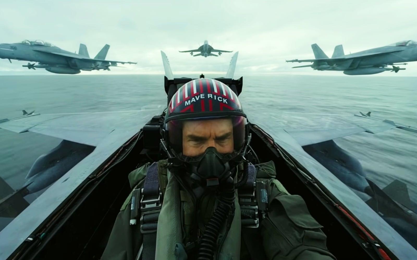 Tom Cruise flying in an F/A-18 Hornet cockpit with 3 more Hornets behind him